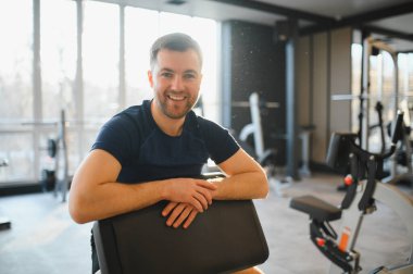 Rehabilitasyon merkezinde fiziksel egzersizden sonra dinlenen mutlu sporcu, başarılarının ve ilerlemesinin tadını çıkarıyor.