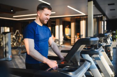 Gülümseyen sporcu, rehabilitasyon ve fiziksel iyileşme için spor salonunda günlük antrenmanına başlıyor.