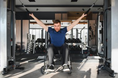 Spor salonunda kablo makinesiyle egzersiz yapan güçlü bir sporcu. Kararlılık gösteriyor ve sağlıklı yaşam tarzını destekliyor.