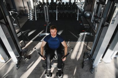 Modern bir spor salonunda halat ile egzersiz yapan engelli genç sporcu rehabilitasyon eğitimi sırasında kararlılık ve güç gösteriyor.