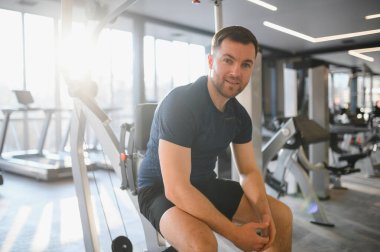 Parlak ve modern bir rehabilitasyon merkezinde fizik tedavi çalışmasını tamamladıktan sonra ara veren gülümseyen adam.