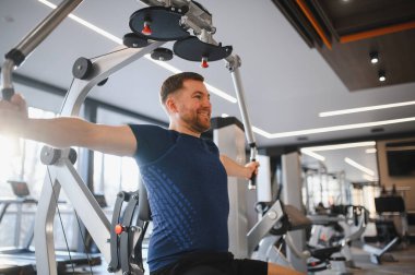 Engelli, sırt kaslarını çalıştıran, ulaşılabilir spor aletleri kullanan, katılımcı fitness ve rehabilitasyonu destekleyen kişiler.