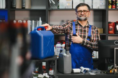 Oto yedek parça mağazasında motor yağı kutusu sunan kıdemli satıcı, küçük işletme ve perakende konsepti