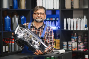 Tamirci, motor yağı ve diğer otomobil ürünleriyle dolu raflarda yeni bir far gösteriyor.