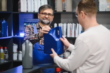 Tamirci, araba tedarikçisinin içindeki müşteriye bir şişe motor yağı veriyor. Bu da temel araç bakımı işlemlerini kolaylaştırıyor.