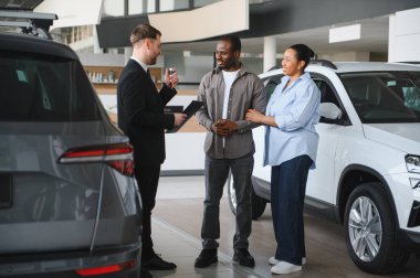 Araba satıcısının elinde araba anahtarı ve sözleşmesi var. Afro-Amerikan çifte satış anlaşmasını açıklıyor.