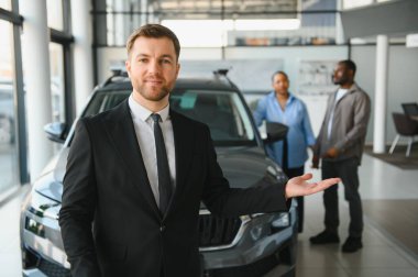 Araba satıcısı, modern bir bayilikte Afro-Amerikan bir çifte yeni bir araba sunuyor. Hayallerindeki aracı seçmek için profesyonel yardım ve rehberlik öneriyor.