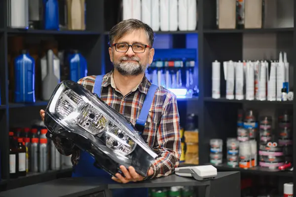 Tamirci, motor yağı ve diğer otomobil ürünleriyle dolu raflarda yeni bir far gösteriyor.