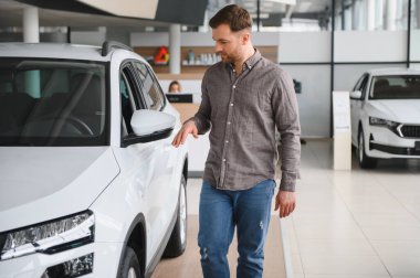 Galerideki yeni beyaz SUV 'u kontrol eden adam, araba mağazasındaki araca dokunuyor, otomobil perakendecisi, satış konsepti