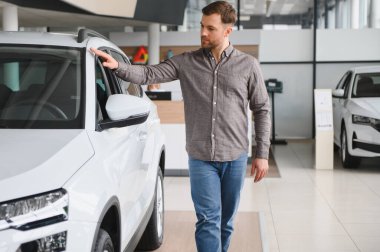 Müşteri araba galerisinde yeni bir SUV 'u inceliyor. Satın alma seçeneklerini de hesaba katarsak.