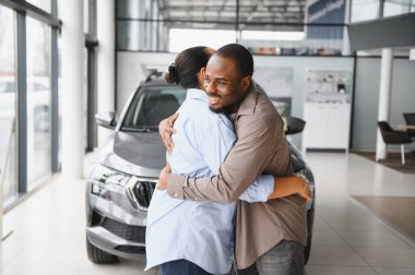 Bir galeri galerisinde kucaklaşan heyecanlı çift hayallerindeki arabanın satın alınmasını kutluyor ve birlikte keyifli bir anı paylaşıyorlar.