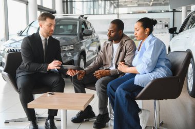 Araba satıcısı Afrikalı Amerikalı çifte satış sözleşmesini açıklarken bayiden yeni bir araba alıyor.