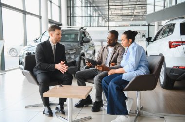 Satış elemanı, yeni araba alımlarının detaylarını açıklarken bir çiftle takılıyor.