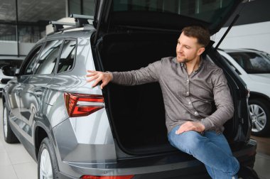 Bir otomobil galerisindeki pratik ve depolama kapasitesi göz önüne alındığında, modern bir cipin kargo alanını değerlendiren potansiyel bir alıcı.