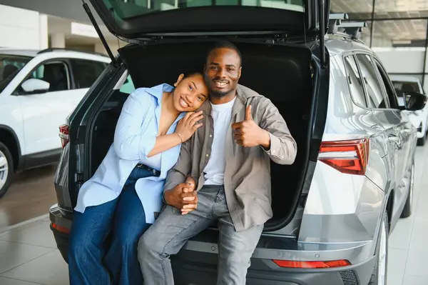 Galerideki yeni araba alımlarını kutlayan heyecanlı çift, başparmaklarını göstererek birlikte mutluluk ve memnuniyet yayıyorlar.