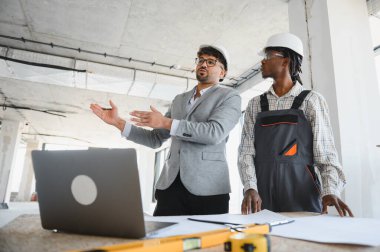 İnşaat alanındaki bir toplantı sırasında inşa edilecek projeyi açıklarken mimar hareketi