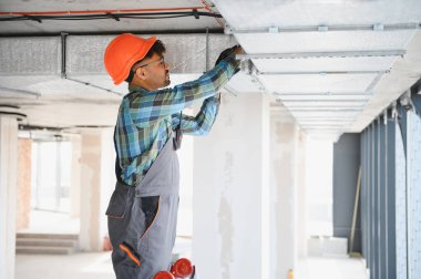 İnşaat sahasında havalandırma sistemi kurulumu üzerinde çalışan Arap mühendis düzgün hava akışı ve işlevsellik sağlıyor