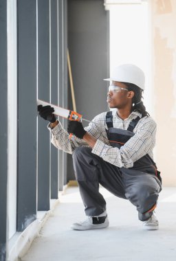 Yeni binada hava geçirmez ve enerji tasarrufu sağlayan, pencere çerçevesine dolgu macunu uygulayan yetenekli inşaat işçisi