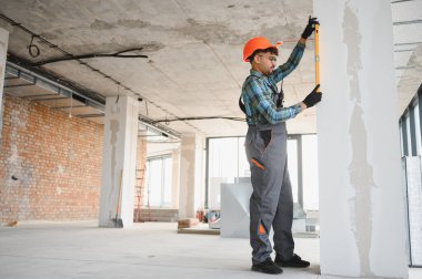 Arap inşaat işçisi, bina tadilatı sırasında ruhsal düzeyde kalite kontrolü yapıyor.