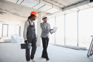 İnşaat halindeki inşaatçının bina planlarını dizüstü bilgisayarda gösteren mimar