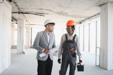 Mimarın elinde bina yapım aşamasında olan bir alet çantası taşıyan inşaatçıyla tartıştığı bir proje var.