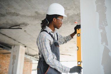İnşaat sırasında duvarın dikey hizalanmasını sağlayan, inşaat alanında hassasiyet ve uzmanlık gösteren profesyonel bir inşaatçı.