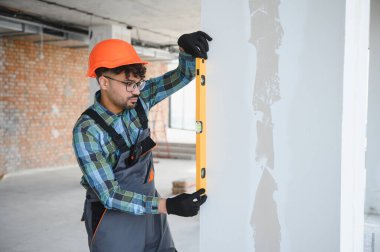 İnşaat alanında ruhsal bir seviye kullanan Arap mühendis inşaat çalışmaları sırasında duvarın tamamen dikey olmasını sağlıyor.