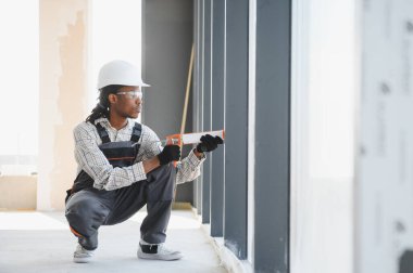 Yeni binaya hava geçirmez ve enerji tasarrufu sağlayan, pencere çerçevesini kapatmaya odaklanan yetenekli inşaat işçisi