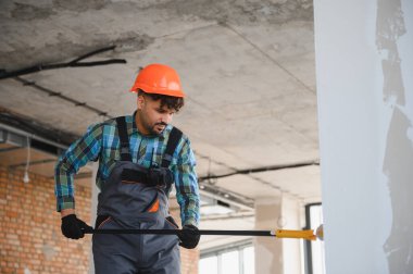 Bir inşaat sahasında ölçüm alan odaklı mühendis, inşaat projesi için hassas hesaplamalar sağlıyor