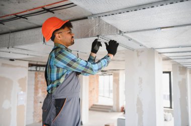 İnşaat sahasında havalandırma sistemi kurulumu üzerinde çalışan Arap mühendis düzgün hava akımı ve iklim kontrolü sağlıyor.