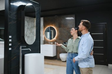 Modern bir galeride banyo yenileme projeleri için seramik fayanslar ve tesisat malzemeleri seçiyorlar.