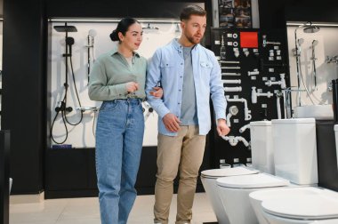 Genç çift, tuvalette yeni bir klozet seçiyor. Tuvalet tadilatı hakkında tartışıyor ve karar veriyorlar.