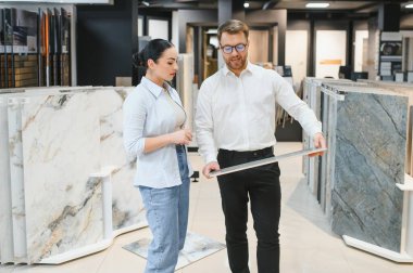 Kadın müşteri, çeşitli seramik seramik seramik ve su tesisatı dükkanlarında erkek bir satıcıyla fayans seçimlerini tartışıyor.