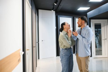 Mutlu çift yeni iç kapılar seçiyor, mobilya mağazasında kararları tartışıyor ve birlikte veriyorlar.