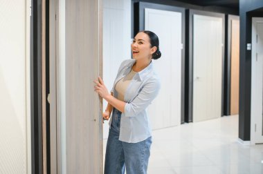 Mutlu müşteri bir kapı açıyor, bir hırdavatçıda iç tasarım unsurlarını seçiyor, satın alma kararı veriyor