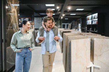 Mutlu aile, seramik fayansları ev yenilemeleri için seçerken aynı zamanda parlak ve modern bir hırdavatçıda kaliteli zaman geçiriyorlar.