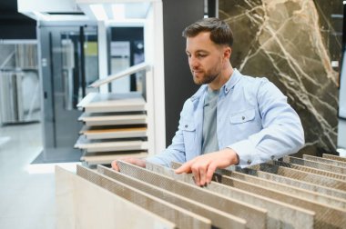 İnşaat veya yenileme projesi için bir ev geliştirme mağazasından kiremit örnekleri seçen mimar