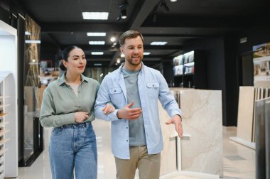 Mutlu çift bir inşaat malzemeleri dükkanında seramik seramik fayanslar seçiyor.