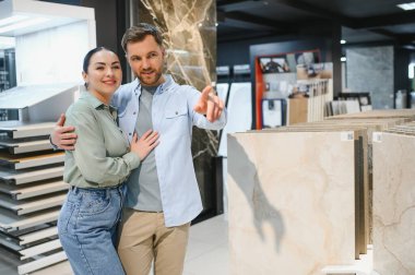 Mutlu çift, modern bir hırdavatçıda dairelerini yenilemek için seramik fayanslar seçiyor ve birlikte ev geliştirme sürecinin keyfini çıkarıyorlar.