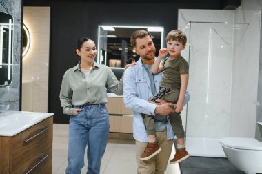 Mutlu bir aile, tesisat dükkanında yeni banyo demirbaşlarını seçiyor. Tadilat planlarken birlikte vakit geçiriyorlar.