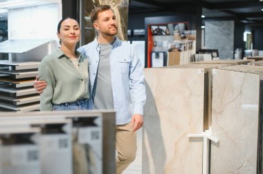 Seramik fayans ve tesisat dükkanında banyo yenileme için seramik fayanslar seçen çift.