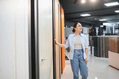 Müşteri seramik fayans ve su tesisatı mağazasında iç tasarım elementlerini seçiyor, alışveriş deneyiminden keyif alıyor