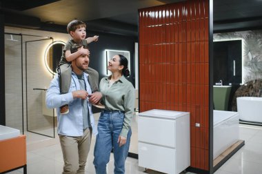 Mutlu aile seramik fayansları ve banyo armatürlerini seçiyor. Tesisatçıda iyi vakit geçiriyorlar.