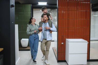 Aile, modern bir seramik fayans ve tesisat mağazasına göz atmaktan, çeşitli banyo armatürleri ve ev dekorasyonu seçeneklerini sergilemekten hoşlanıyor.