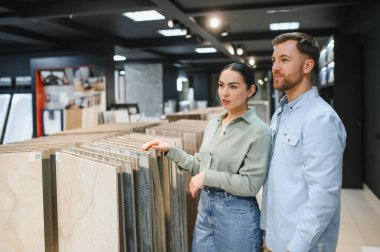 Çift seramik fayansları seçiyor, tartışıyor ve farklı örneklere işaret ediyor.