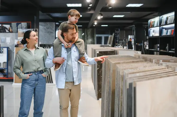 Mutlu aile, seramik fayansları seçerken parlak ve modern bir hırdavatçıda birlikte vakit geçiriyorlar.