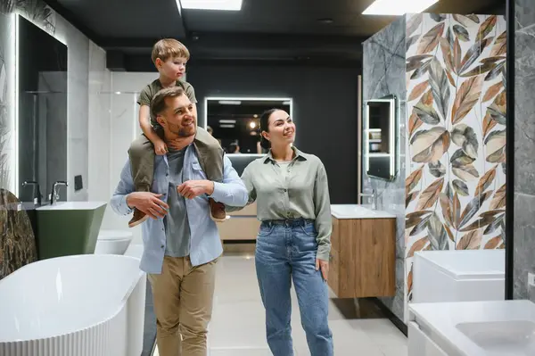 Mutlu aile seramik fayanslar ve banyo demirbaşlarını bir tesisat mağazasında seçiyor, birlikte kaliteli zaman geçiriyorlar ve ev iyileştirme seçimleri yapıyorlar.