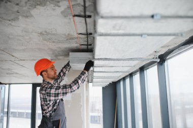 İnşaat işçisi yoğun bir şantiyeye havalandırma ve havalandırma sistemi kurarak, kapalı alanda en uygun iklim kontrolünü sağlıyor.
