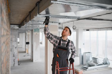 Profesyonel müteahhit, yoğun bir inşaat sahasına uygun havalandırma ve konfor sağlayan aletlerle bir havalandırma sistemi kuruyor.