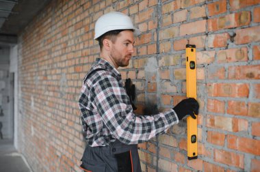 Ruh seviyesini kullanan inşaatçı tuğla döşeme sırasında hassas bir hizalama sağlar, inşaat kalitesinde doğruluk ve kalite vurgulanır